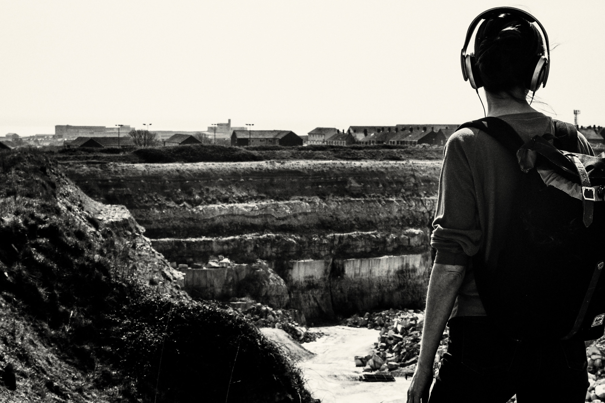 person standing at edge of giant earthen pit