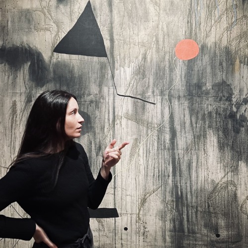 Fosca Maddaloni standing in front of an abstract painting