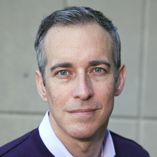 Headshot of man in purple shirt