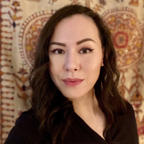 Woman with brown hair in front of a patterned background