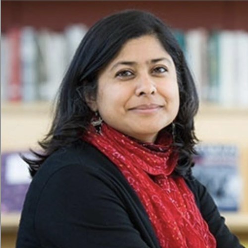 Photo of VAzira F-Y Zamindar sitting in front of bookshelf