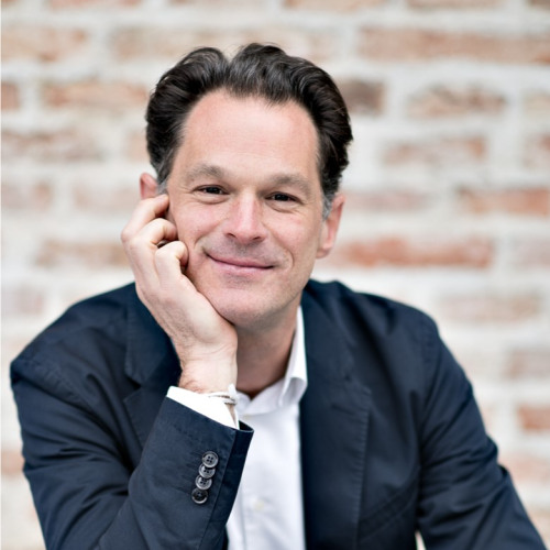 man with brown hair and suit jacket sitting